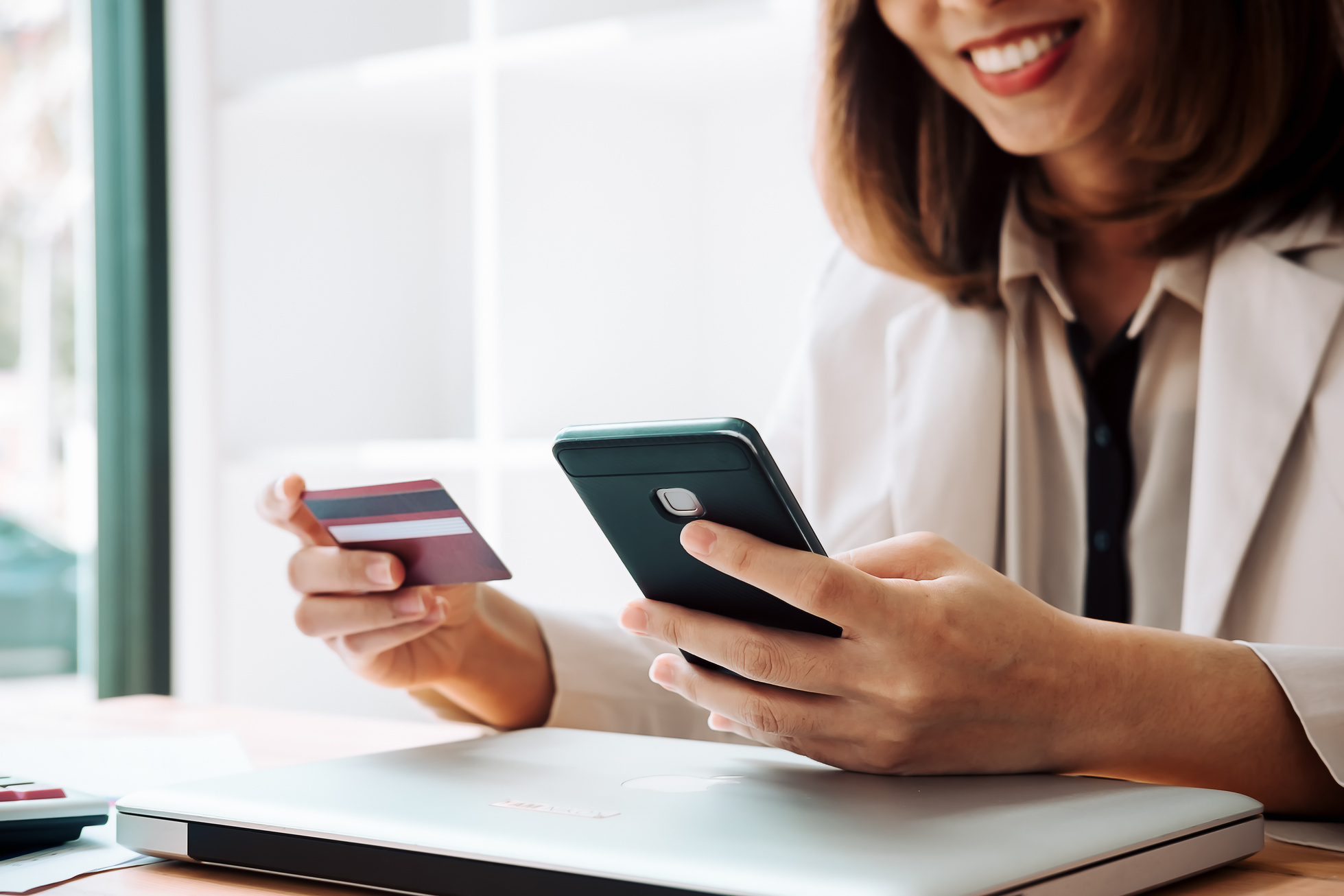 Woman Holding Credit Card and Using Phone Online Shopping